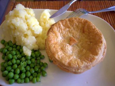 Traditional Aussie meat pie with mashed potato and peas