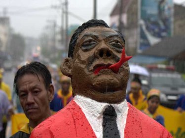 The PM is pushed in effigy through wet Phuket on Saturday