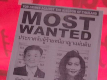 Wanted notice for former PM Thaksin and wife on a Phuket window