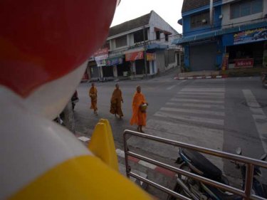 Cultures meet as monks are waied at a burger joint in Phuket City
