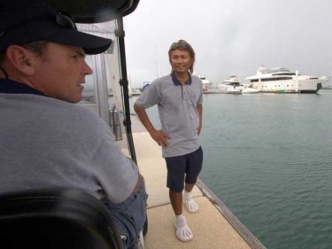 Simon Grant (left) on a golf cart at Ao Po Grand Marina