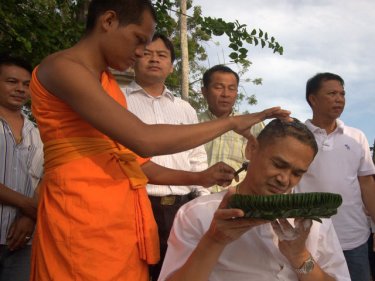 A man has his head shaved on the way to becoming a monk today