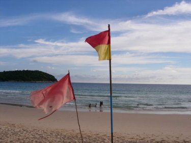 Flags fly at Naiharn beach, one of Phuket's popular swimming destinations