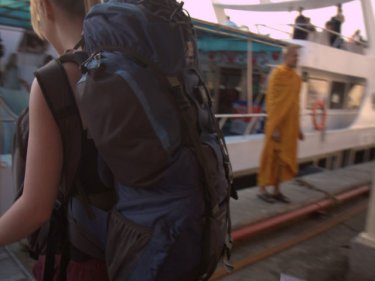 A backpacker boards a large ferry for Phi Phi at Rassada Port on Phuket