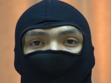 Masked for his protection, a youth appears at Phuket City police station