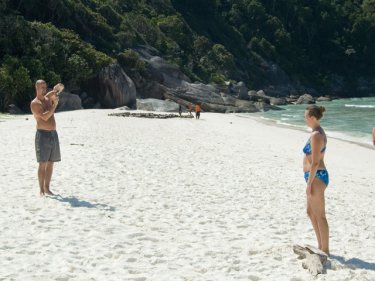 Tourists on one end of a Similans beach, prostrate boatpeople at the other