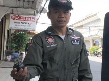 A Phuket policeman shows off the grenade left outside a yellow tv office