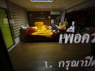 Holy monk Luang Pu Supha lies asleep under his saffron bedspread on Phuket