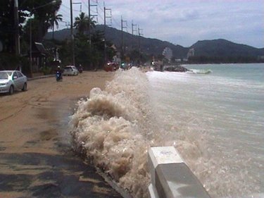 Phuket's scenic beach road awash as high tide waves bring sand ashore