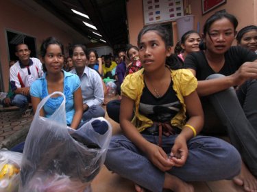 Cambodians wait at Phuket's Immigration HQ for the bus ride home