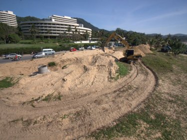 Racing to finish, an earth mover completes a channel at Karon beach