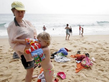 Red flags hold no meaning as a Russian mother prepares for a swim
