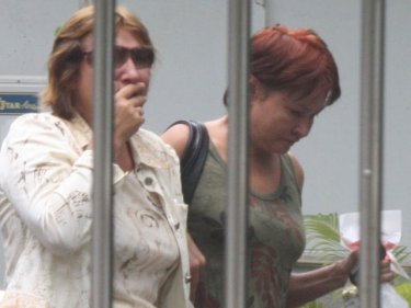 The grieving mother of Maksim Schantz is escorted to a Phuket hospital