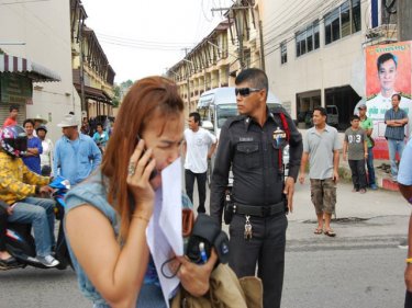 Khun Ji takes a call at the spot where her husband was killed today