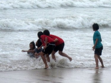 Visiting athletes indulge in some play in the surf at Phuket's Patong beach
