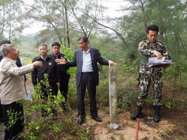 Khun Damrung checks a park marker with construction beyond it