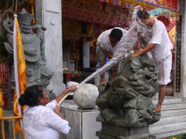 Cleaning up at Jui Tui Temple as workers earn a cold spray today