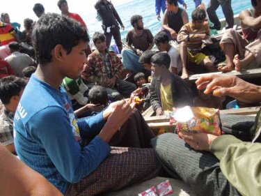 Children enjoy snacks off Phuket after 13 days at sea in an open boat