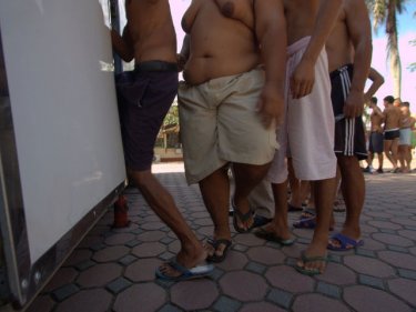 Male inmates queue for a health check inside Phuket Prison