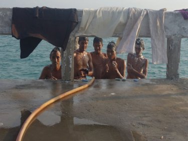 Rohingya wash after surviving 45 days at sea on a voyage via India