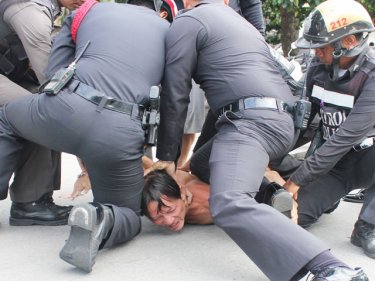 The man is subdued by two truckloads of police in Phuket City today