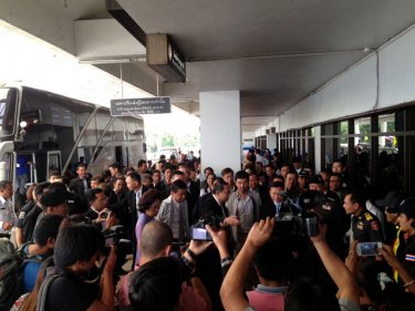 The media throng surrounds officials outside Phuket airport today