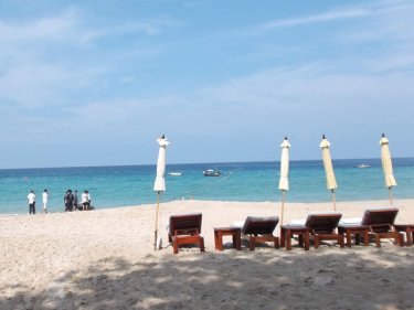 The man's naked body with a cupid tattoo on a Phuket beach today