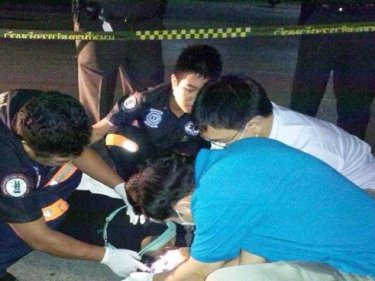 Paramedics at the Phuket killing scene early today. The woman died instantly