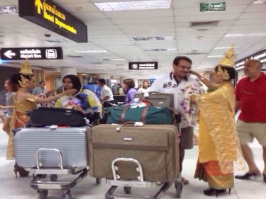 The Indian couple are greeted at Phuket airport as they arrive to wed