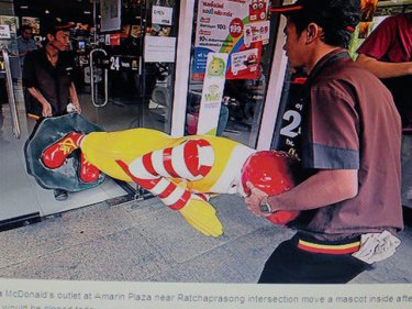 Bangkok workers remove the Mac man from a site popular with protesters