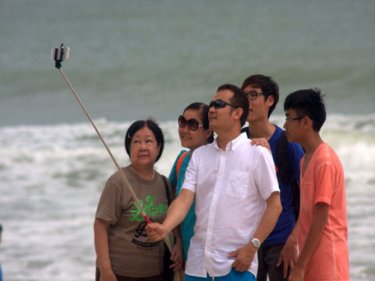 Tourists take a ''groupie'' at Patong's remarkably clear beach yesterday