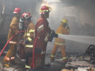 Firemen battle the blaze at the Chinese temple on Phuket today