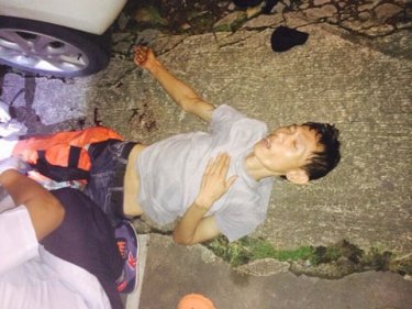 The shot Phuket bandit lying wounded near his getaway car last night