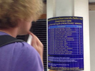 A tourist checks the outdated taxi fares list at Phuket airport yesterday
