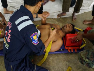 A sick boatperson, suffering exhaustion, is taken to hospital by paramedics