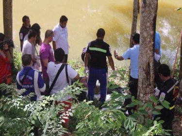 The man's body is fetched from the pond in Phuket City this afternoon