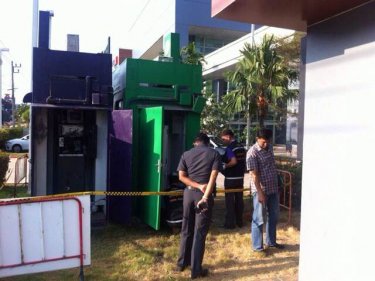 Police inspect the area around the ATMs for clues today