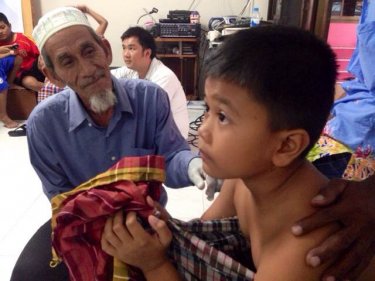 Hem Saboot checks on the wellbeing of a boy at the mass circumcision