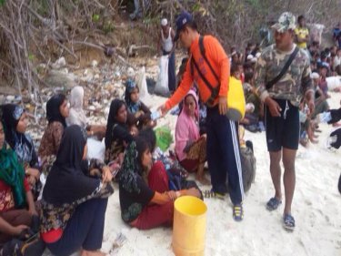 Boatpeople being given food by Royal Thai Navy sailors late yesterday