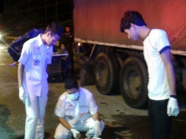 Paramedics attend to a truck crash in which a motorcyclist died today