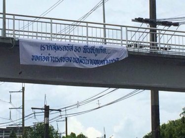 The protest sign says: Local buses are against nominee foreign vehicles